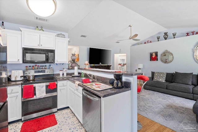 6819 Old W Ln, Milton, FL 32570 - kitchen featuring stainless steel appliances, a peninsula, open floor plan, lofted ceiling, and dark countertops