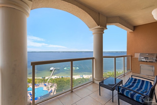 balcony featuring a beach view, grilling area, and a water view