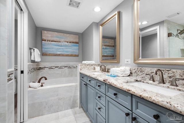 bathroom featuring tile patterned flooring, independent shower and bath, and vanity