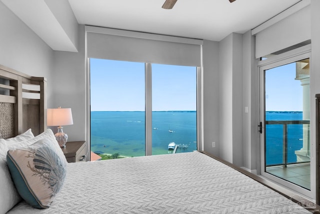 bedroom with access to outside, ceiling fan, and a water view