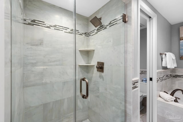 bathroom featuring toilet and an enclosed shower