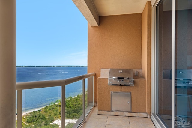 balcony with area for grilling, a beach view, and a water view