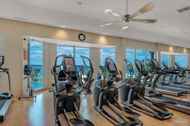 gym featuring light wood-style floors, visible vents, and a ceiling fan