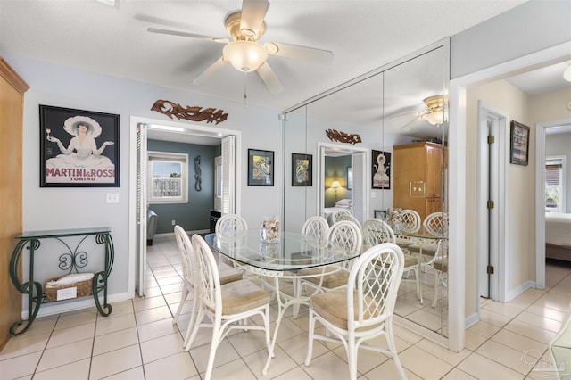 dining area featuring ceiling fan, a textured ceiling, and light tile patterned flooring