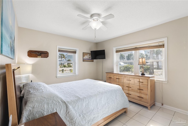 bedroom featuring ceiling fan, a textured ceiling, and light tile patterned floors