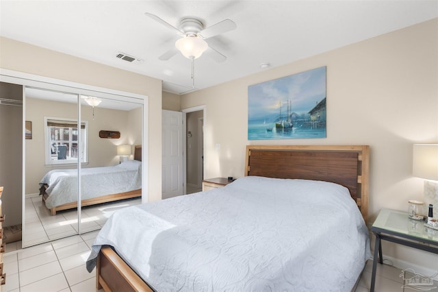 bedroom featuring ceiling fan, light tile patterned floors, and a closet