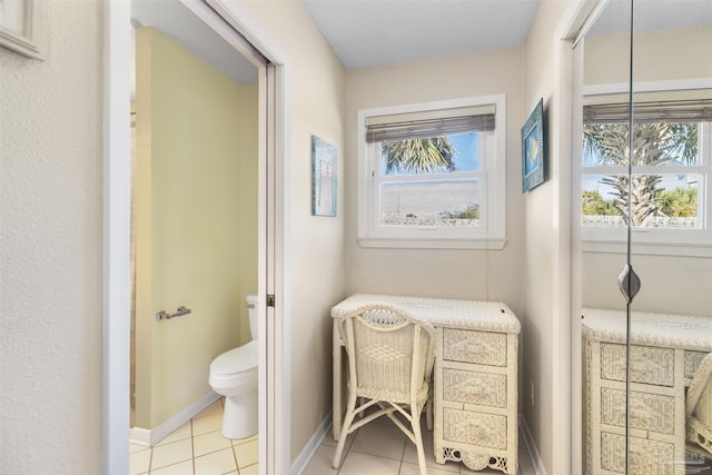 interior space with toilet and tile patterned floors