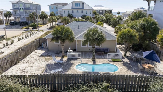 back of property featuring an outdoor hangout area, a patio area, and a fenced in pool