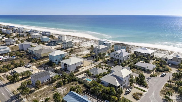 birds eye view of property with a water view and a beach view