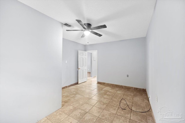 empty room featuring light tile patterned floors, a textured ceiling, and ceiling fan