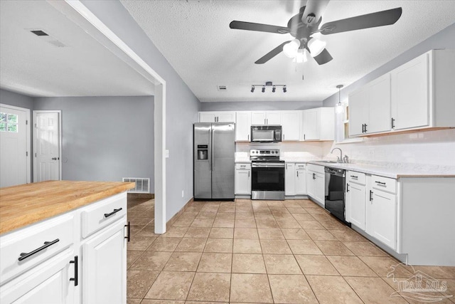 kitchen featuring sink, hanging light fixtures, a textured ceiling, white cabinets, and black appliances