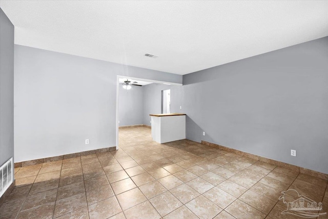 unfurnished room featuring tile patterned floors, ceiling fan, and a textured ceiling