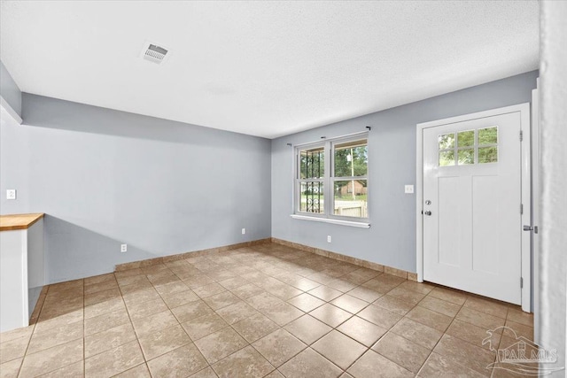 tiled foyer entrance with a textured ceiling