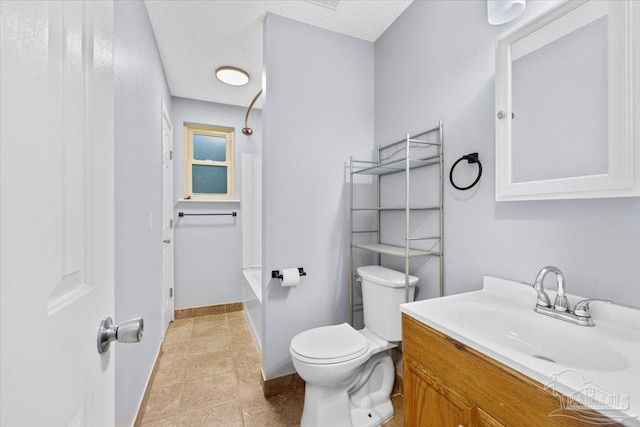 bathroom with tile patterned floors, vanity, a textured ceiling, and toilet