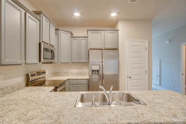 kitchen featuring stainless steel appliances, sink, and gray cabinetry