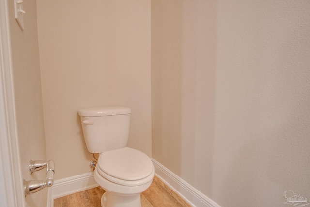 bathroom with hardwood / wood-style flooring and toilet