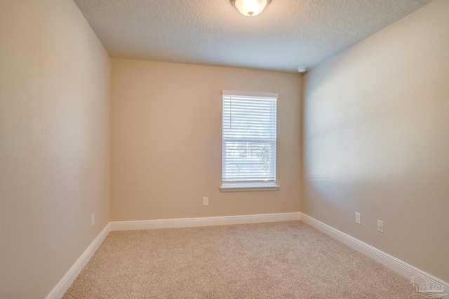 carpeted empty room with a textured ceiling