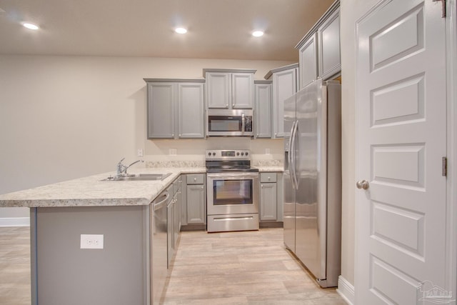 kitchen featuring stainless steel appliances, sink, light hardwood / wood-style floors, and gray cabinets