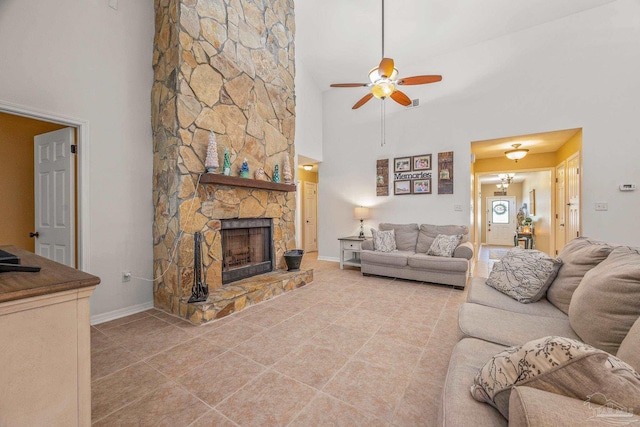 living room featuring ceiling fan, a fireplace, baseboards, and tile patterned floors