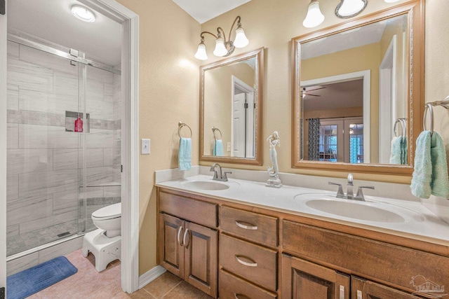 full bathroom featuring double vanity, a shower stall, a sink, and tile patterned floors