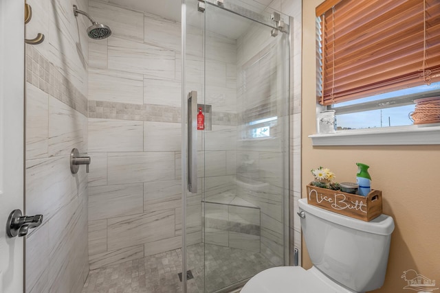 full bath featuring a stall shower and toilet