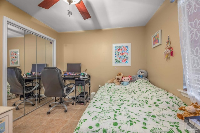 tiled bedroom with ceiling fan and a closet