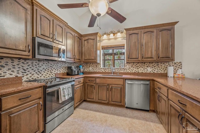 kitchen with light tile patterned floors, decorative backsplash, appliances with stainless steel finishes, a ceiling fan, and a sink