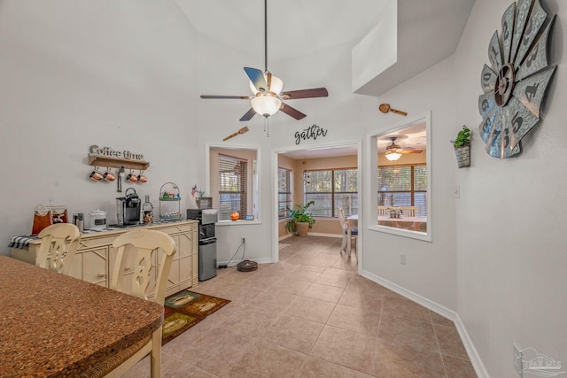 dining space with light tile patterned floors, baseboards, and a ceiling fan