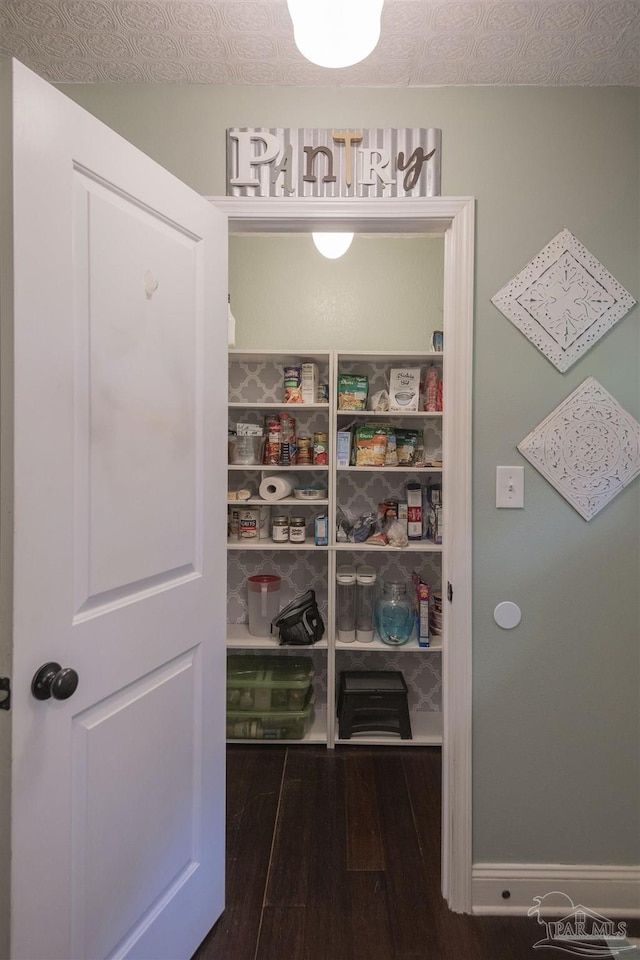 bedroom featuring ceiling fan, a textured ceiling, and dark wood-type flooring