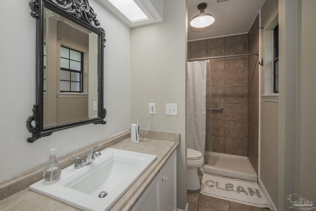 bathroom with walk in shower, vanity, toilet, and tile patterned flooring