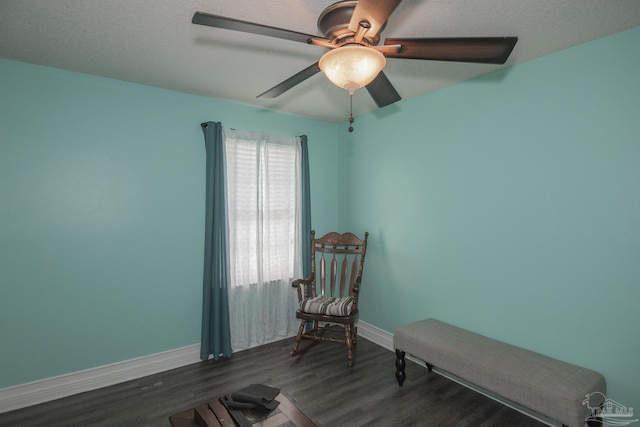 sitting room featuring ceiling fan, dark hardwood / wood-style floors, and a textured ceiling