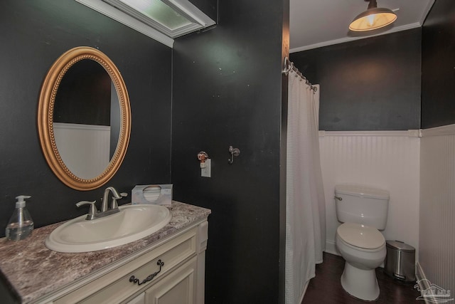 bathroom with hardwood / wood-style flooring, ornamental molding, vanity, and toilet