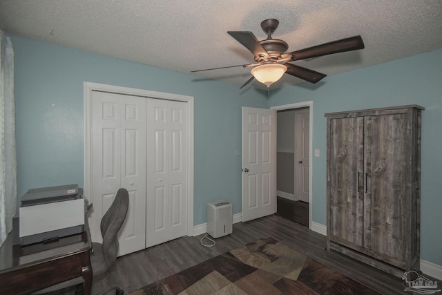 office space with a textured ceiling, dark wood-type flooring, and ceiling fan