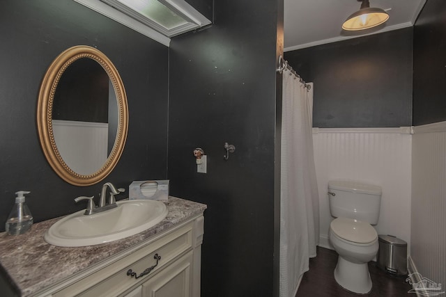 bathroom with vanity, wood-type flooring, crown molding, and toilet