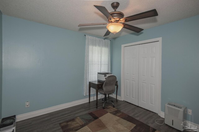 office area with ceiling fan, dark wood-type flooring, and a textured ceiling