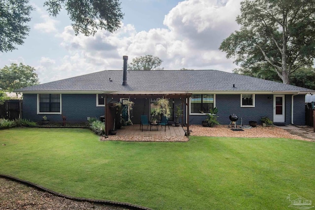 rear view of property with a patio and a lawn