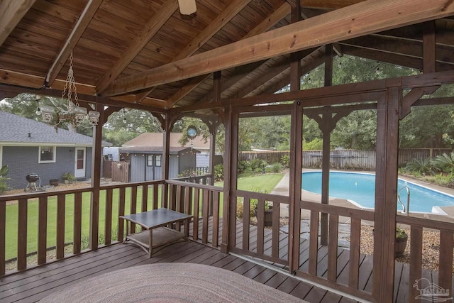 deck featuring a shed and a lawn