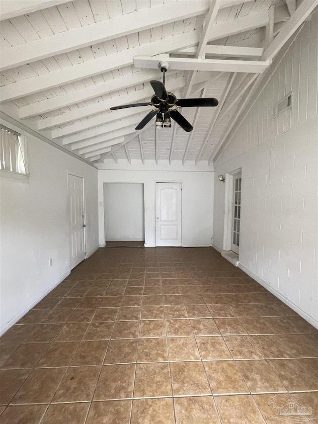 empty room with ceiling fan, vaulted ceiling with beams, wooden ceiling, and tile patterned flooring