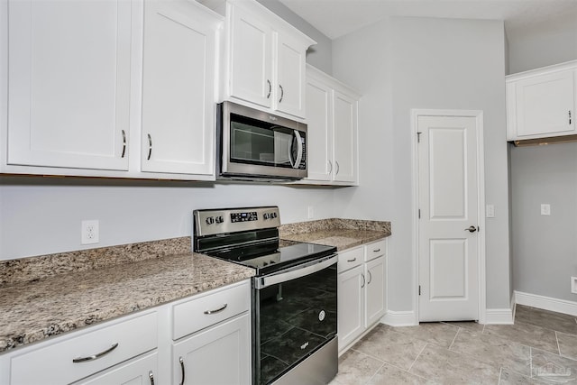 kitchen with appliances with stainless steel finishes, light stone counters, and white cabinets