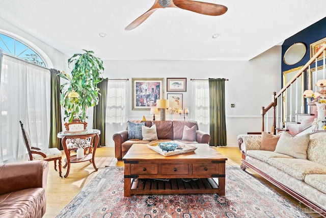 living room with ceiling fan and light hardwood / wood-style flooring