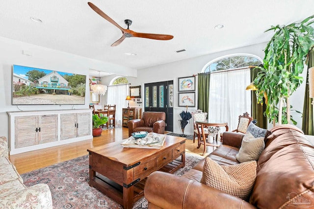 living room featuring hardwood / wood-style floors and ceiling fan with notable chandelier