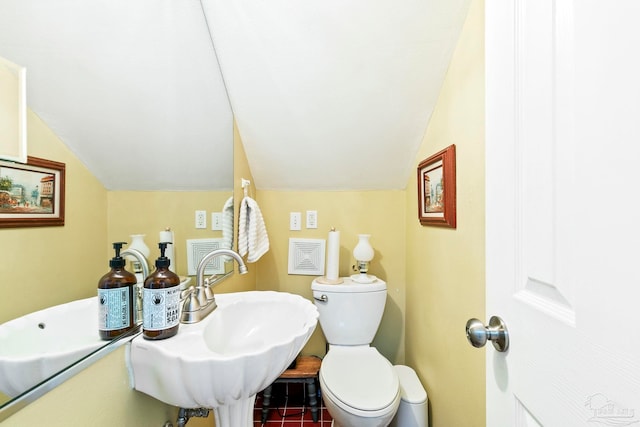 bathroom featuring tile patterned flooring, toilet, lofted ceiling, and sink