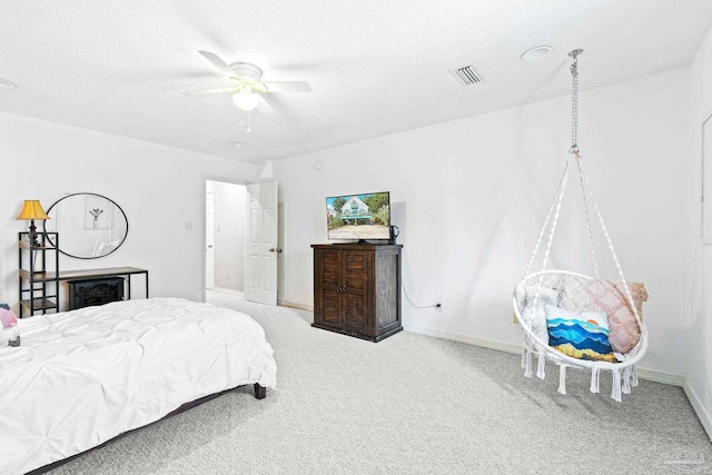 bedroom featuring ceiling fan, carpet floors, and a textured ceiling