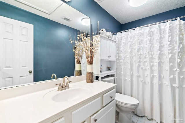 bathroom featuring tile patterned floors, vanity, a textured ceiling, and toilet