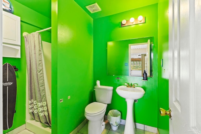 bathroom with tile patterned flooring, curtained shower, and toilet