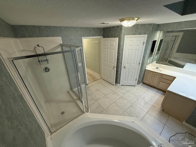 full bathroom with vanity, a bathing tub, tile patterned flooring, a shower stall, and a textured ceiling