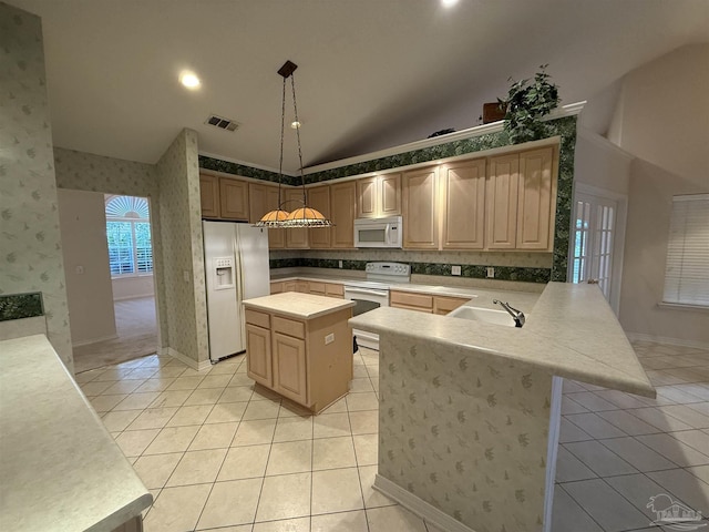 kitchen featuring white appliances, light tile patterned floors, wallpapered walls, a peninsula, and a sink