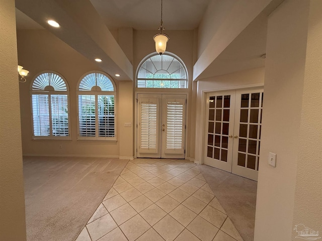 entrance foyer featuring light tile patterned floors, recessed lighting, light colored carpet, and french doors