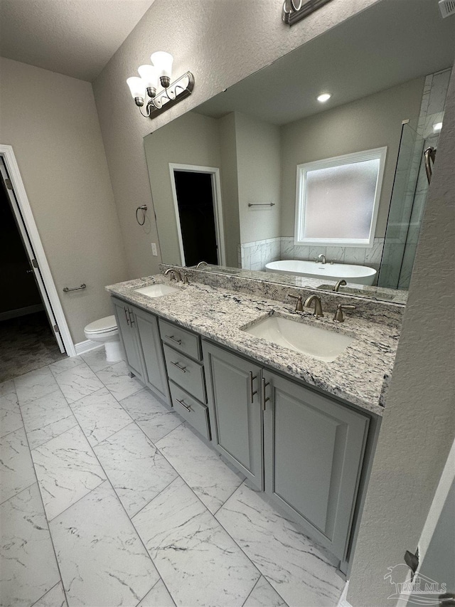 bathroom featuring vanity, toilet, a chandelier, and a bathtub