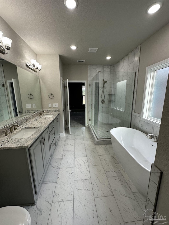 bathroom featuring vanity, shower with separate bathtub, and a textured ceiling